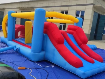 Inflatable obstacle course with dual red slides and vibrant blue-yellow design. Perfect for kids' events. Buy durable inflatables online in Australia today!